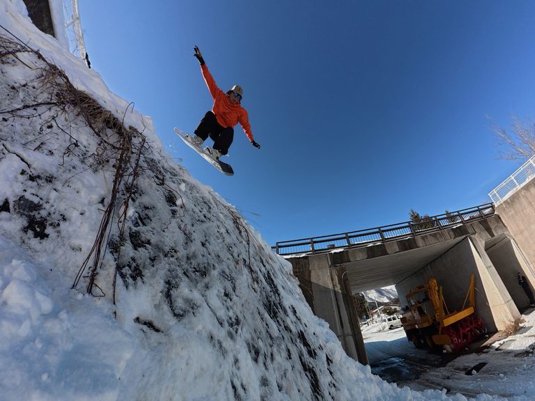 Rinat mid-air on a snowboard.